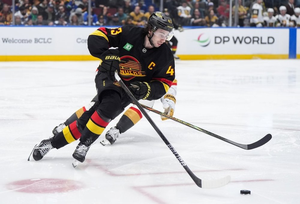 Vancouver Canucks' Quinn Hughes (43) skates with the puck away from Vegas Golden Knights' Tanner Pearson, back, during the second period of an NHL hockey game in Vancouver, on Sunday, April 6, 2025. THE CANADIAN PRESS/Darryl Dyck