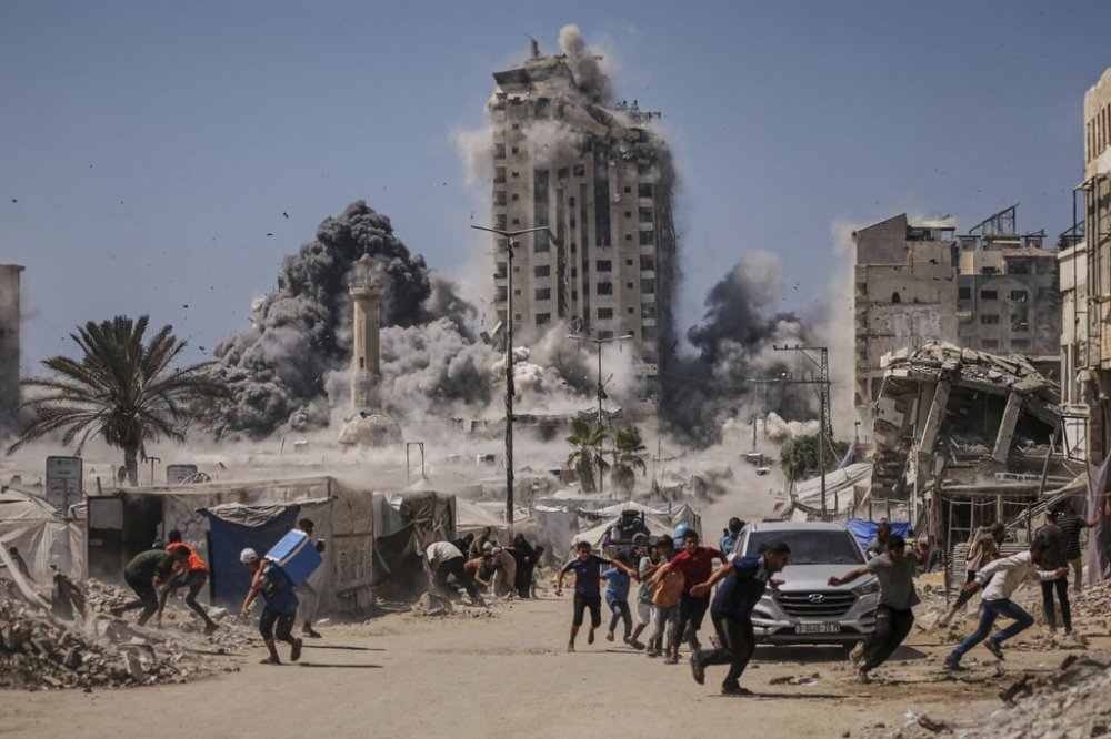FILE - Palestinians run for cover during an Israeli airstrike on a high-rise building in Gaza City, Friday, Sept. 5, 2025, after the Israeli army issued a warning. (AP Photo/Yousef Al Zanoun, File)