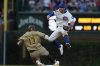 Chicago Cubs' Dansby Swanson leaps over San Diego Padres' Manny Machado to make a play on a ball hit by Jackson Merrill during the sixth inning of Game 3 of a National League wild card baseball game Thursday, Oct. 2, 2025, in Chicago. (AP Photo/Nam Huh)