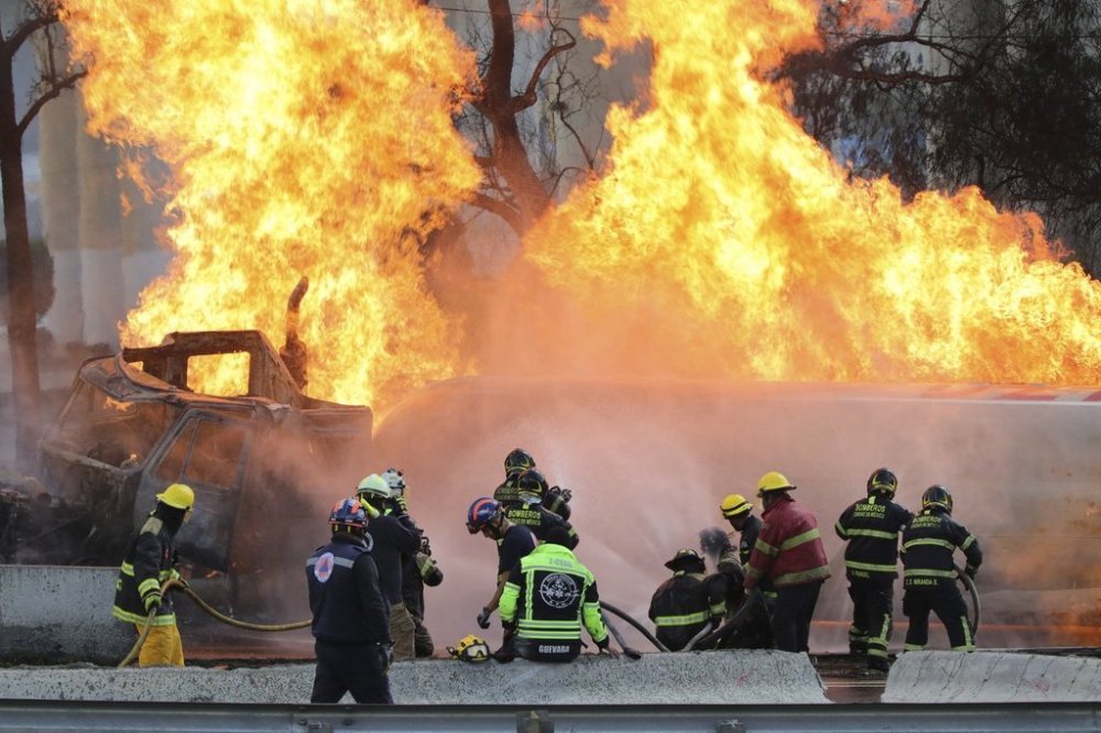 Firefighters spray hoses at a gas tanker that exploded under a highway overpass in Mexico City, Wednesday, Sept. 10, 2025. (AP Photo/Tristan Velazquez)