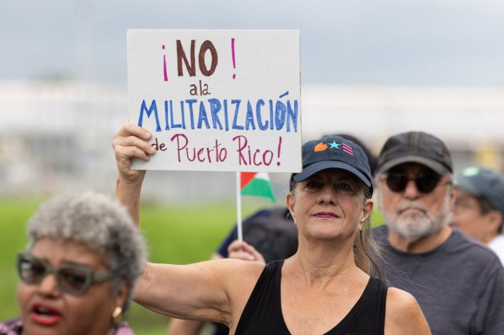 A demonstrator holds a sign that reads in Spanish,