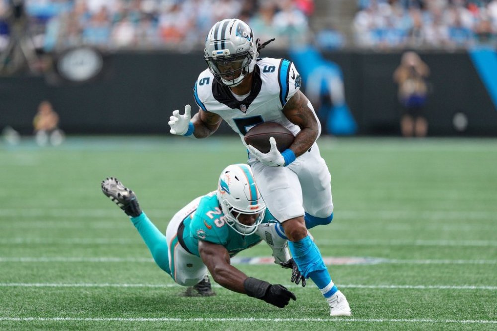 Carolina Panthers running back Rico Dowdle runs past Miami Dolphins linebacker Tyrel Dodson during the first half of an NFL football game, Sunday, Oct. 5, 2025, in Charlotte, N.C. (AP Photo/Jacob Kupferman)