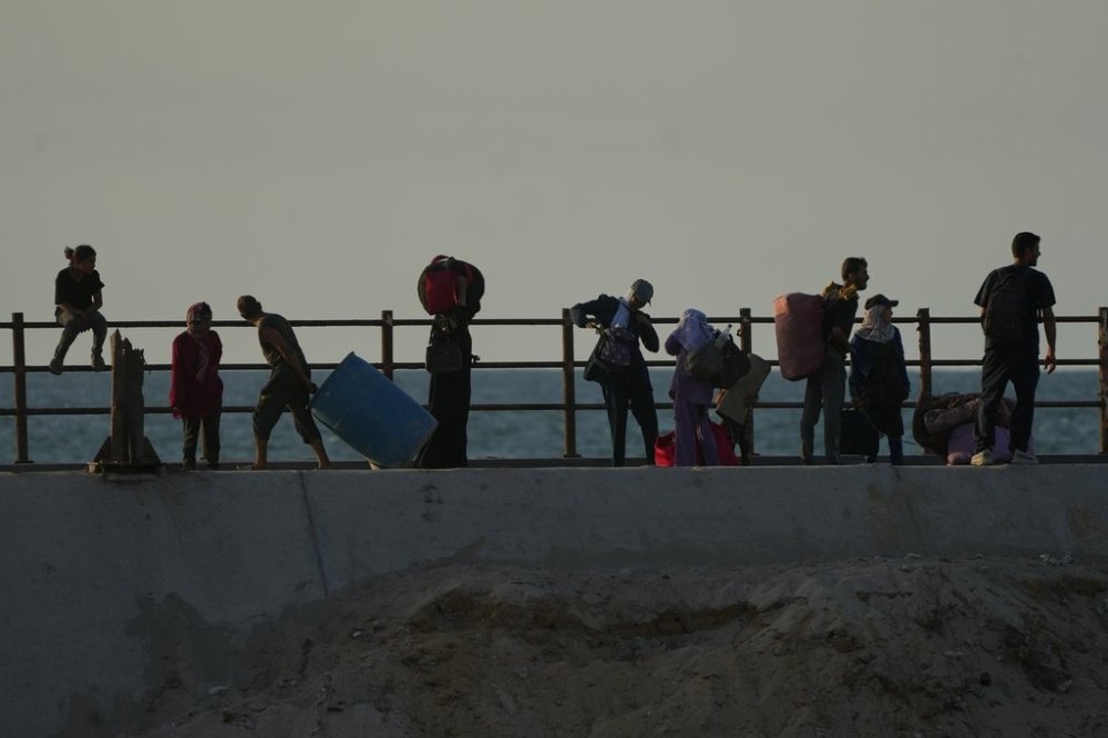 Displaced Palestinians flee northern Gaza carrying their belongings along the coastal road near Wadi Gaza, Thursday, Oct. 2, 2025. (AP Photo/Abdel Kareem Hana)
