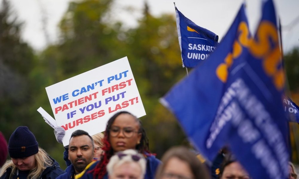 People hold signs and flags during a rally organized by Saskatchewan Union of Nurses in Regina, on Thursday, October 3, 2024. THE CANADIAN PRESS/Heywood Yu