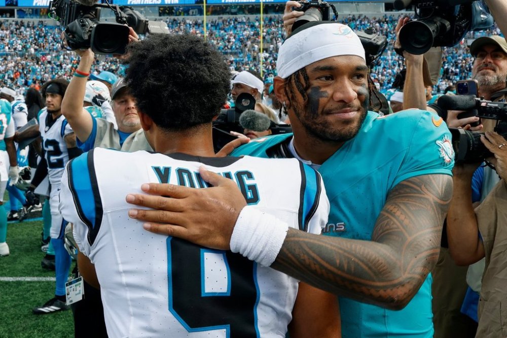 Miami Dolphins quarterback Tua Tagovailoa hugs Carolina Panthers quarterback Bryce Young after an NFL football game, Sunday, Oct. 5, 2025, in Charlotte, N.C. (AP Photo/Rusty Jones)
