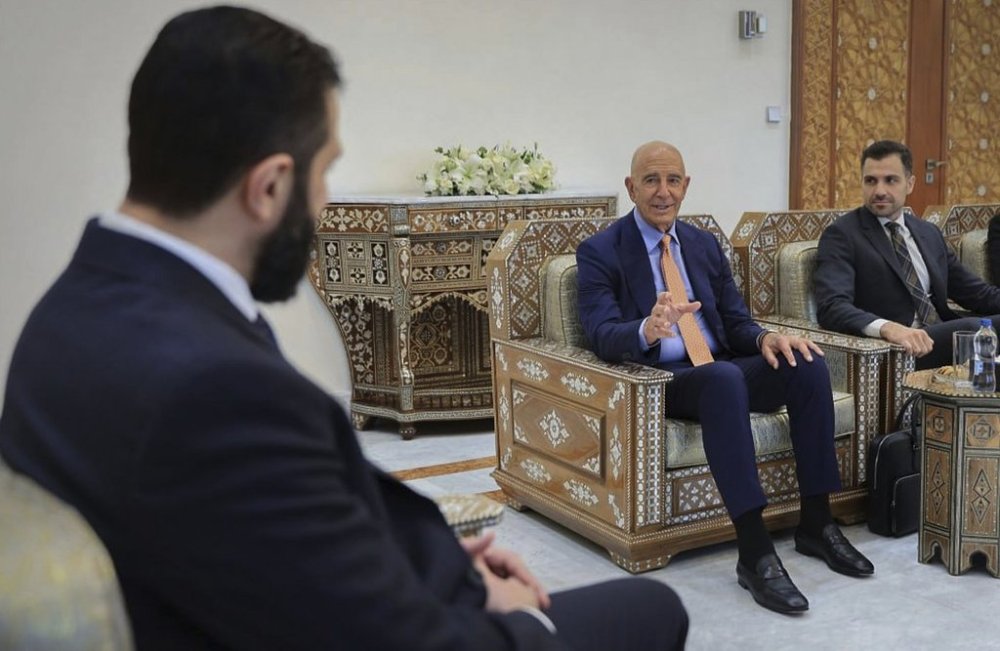 In this photo released by the Syrian official news agency SANA, U.S. Ambassador to Turkey and Special Envoy to Syria Tom Barrack, right, centre, meets with Syria's interim President Ahmad al-Sharaa,, left, in Damascus, Syria, Monday, Aug. 25, 2025. (SANA via AP)