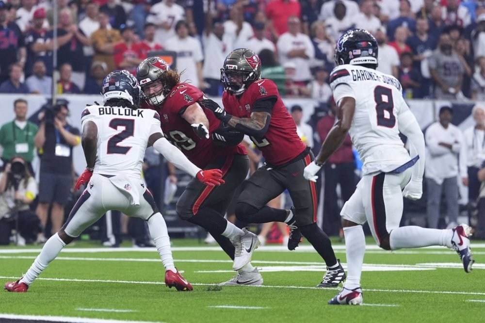 Tampa Bay Buccaneers wide receiver Emeka Egbuka (2) sprints to the end zone to score a touchdown as Houston Texans' Calen Bullock (2) and C.J. Gardner-Johnson (8) defend in the first half of an NFL football game Monday, Sept. 15, 2025, in Houston, Texas. (AP Photo/Eric Gay)