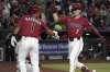 Arizona Diamondbacks' Corbin Carroll, right, celebrates with Jorge Barrosa (1) after hitting a three-run home run against the Philadelphia Phillies in the second inning of a baseball game, Sunday, Sept. 21, 2025, in Phoenix. (AP Photo/Rick Scuteri)