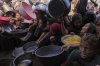 Palestinians struggle to get donated food at a community kitchen in Khan Younis, southern Gaza Strip, Friday, Sept. 19, 2025. (AP Photo/Jehad Alshrafi)