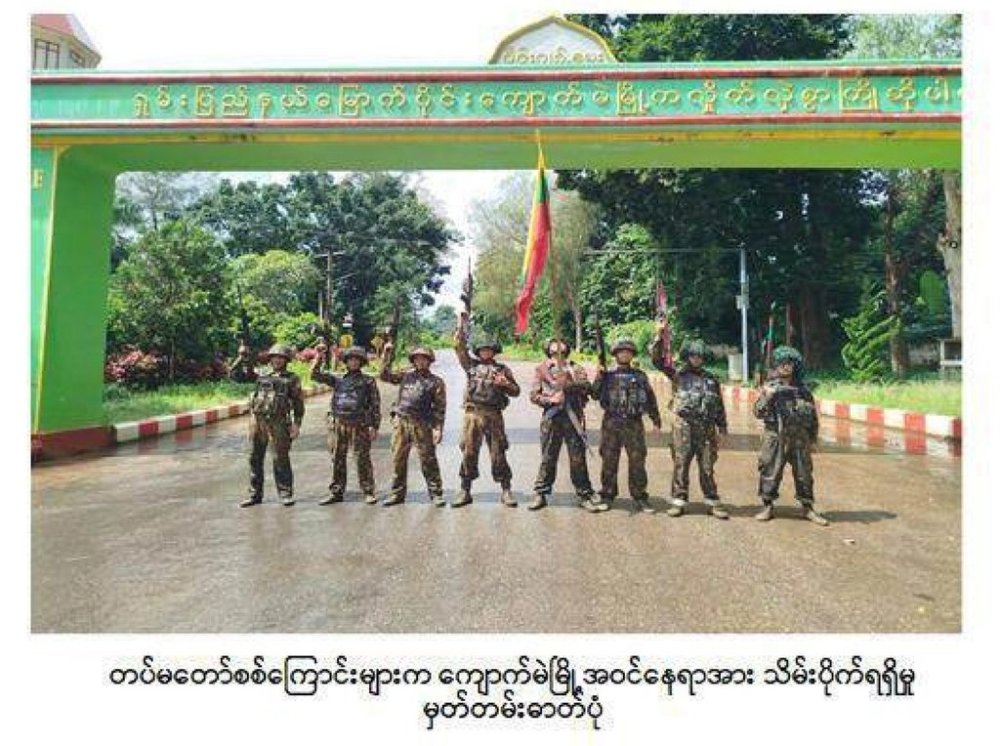 In this image released on Oct. 1, 2025 by the Myanmar Military, soldiers pose for a photo in front of the entrance gate of Kyaukme, a town that the resistance forces had controlled for more than a year, in the northern part of Shan state. (Myanmar Military via AP)