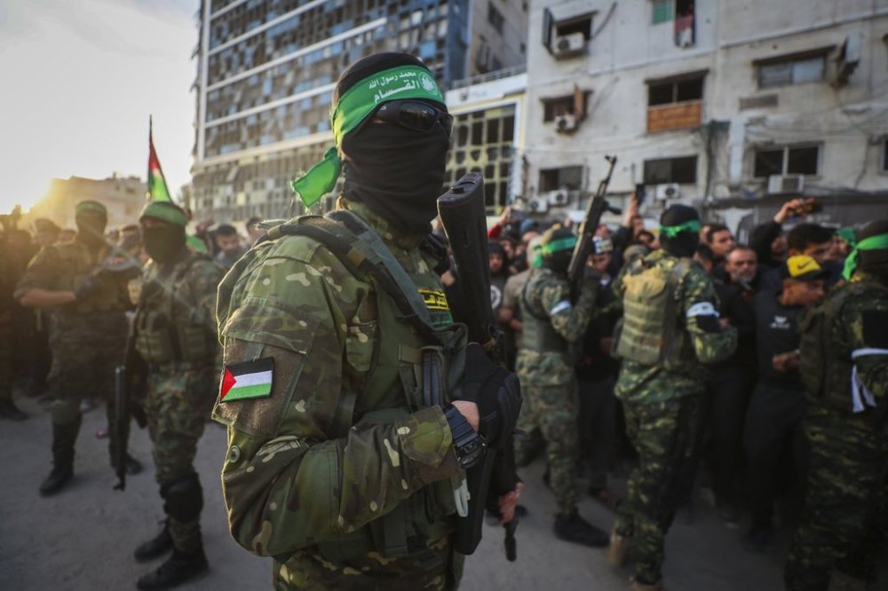 FILE - Fighters from the Qassam Brigades, the military wing of Hamas, control the crowd while Red Cross collect Israeli hostages to be released under a ceasefire agreement between Israel and Hamas, in Gaza City, Jan. 19, 2025. (AP Photo/Abed Hajjar, File)