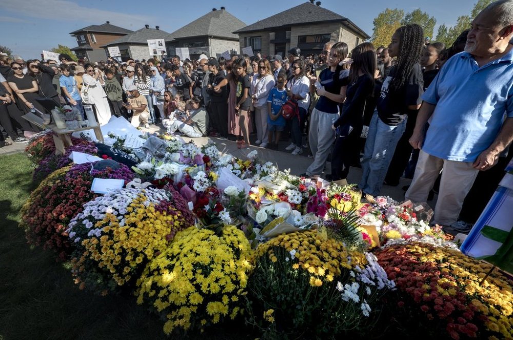 Hundreds of people pass by a a memorial for Nooran Rezayi, in Longueuil, Que., Saturday, Sept. 27, 2025. Rezayi, a 15-year-old boy, was shot dead by police after officers responded to a 911 call about a group of armed young people in a public place in Longueuil. THE CANADIAN PRESS/Peter McCabe