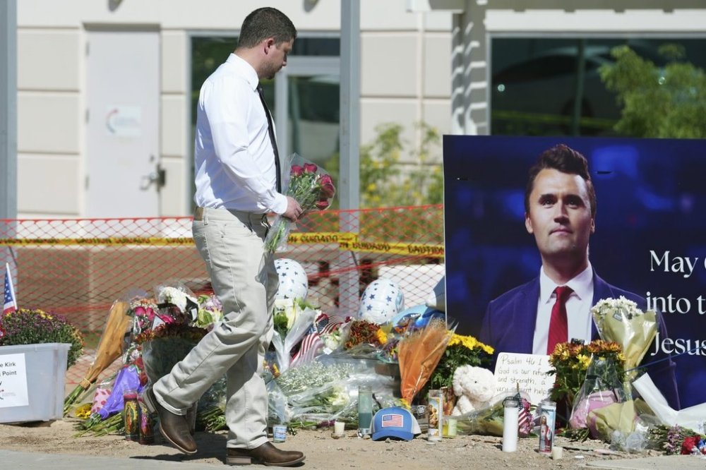 A well-wisher adds flowers to a makeshift memorial set up at Turning Point USA headquarters after the shooting death at a Utah college on Wednesday of Charlie Kirk, the 31-year-old founder and CEO of the organization, Thursday, Sept. 11, 2025, in Phoenix. THE CANADIAN PRESS/AP - Ross D. Franklin