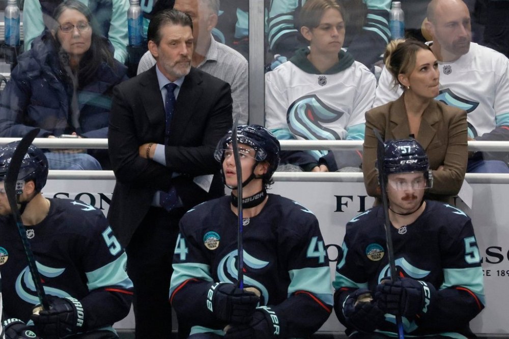 FILE - Seattle Kraken head coach Lane Lambert, left, and assistant coach Jessica Campbell, right, watch from the bench during the third period of a preseason NHL hockey game Sunday, Sept. 21, 2025, in Seattle. (AP Photo/John Froschauer, File)
