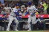 Chicago Cubs' Carson Kelly (15) high-fives third base coach Quintin Berry after hitting a solo home run in the fourth inning of a baseball game against the Atlanta Braves, Wednesday, Sept. 10, 2025, in Atlanta. (AP Photo/Colin Hubbard)