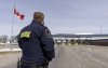A Canada Border Services officer watches as vehicles enter Canada from Vermont at the Highway 55 Port of Entry in Stanstead, Que., Thursday, March 13, 2025. THE CANADIAN PRESS/Christinne Muschi