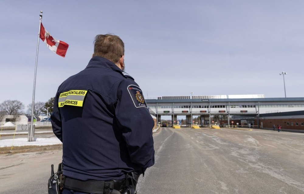 A Canada Border Services officer watches as vehicles enter Canada from Vermont at the Highway 55 Port of Entry in Stanstead, Que., Thursday, March 13, 2025. THE CANADIAN PRESS/Christinne Muschi