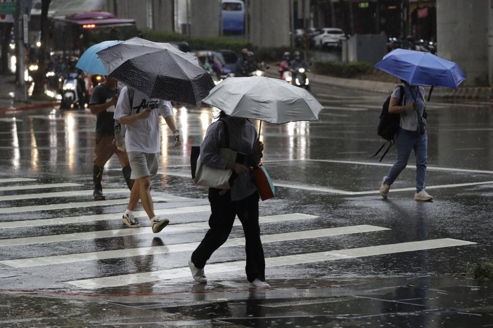 People walk in the rain caused by typhoon Ragasa in Taipei, Taiwan Tuesday, Sept. 23, 2025. (AP Photo/Chiang Ying-ying)