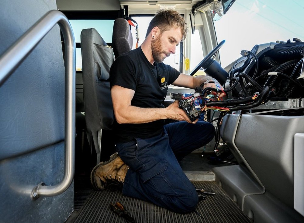 Phil Bougie, head mechanic at Autobus Beaconsfield and Transport Scolaire Élite, inspects the heating control system of a Lion electric school bus at their depot in Montreal, Friday, Sept. 12, 2025, after the government pulled the electric buses off the roads in the province following a fire. THE CANADIAN PRESS/Graham Hughes