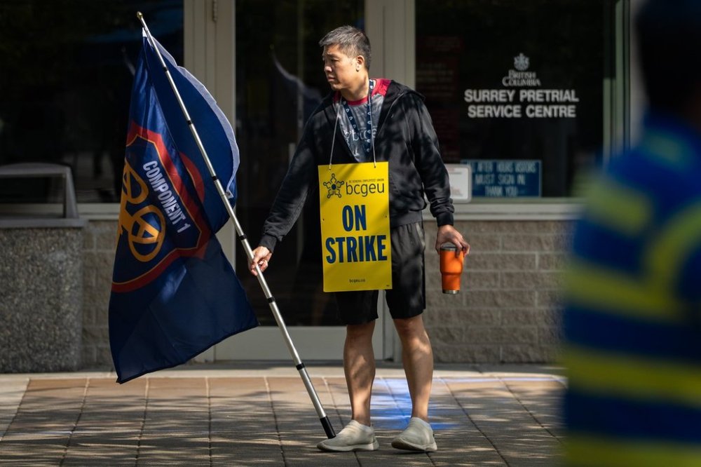 A member of the BC General Employees' Union pickets outside of the Surrey Pretrial Services Centre, in Surrey, B.C., Tuesday, Sept. 9, 2025. THE CANADIAN PRESS/Ethan Cairns