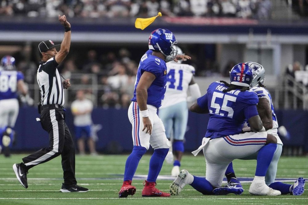 An official throws a penalty flag after a play that involved New York Giants' James Hudson III (55) in the first half of an NFL football game against the Dallas Cowboys Sunday, Sept. 14, 2025, in Arlington, Texas. (AP Photo/Jeffrey McWhorter)