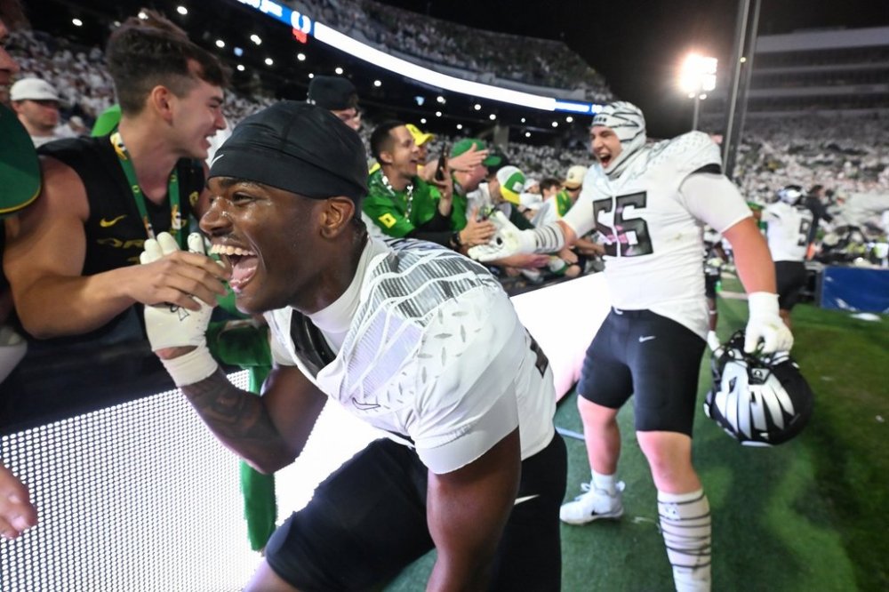 Oregon linebacker Nasir Wyatt (32) and Oregon offensive lineman Trent Ferguson (56) celebrate their second overtime win over Penn State during their NCAA college football game, Saturday, Sept. 27, 2025, in State College, Pa. (AP Photo/Barry Reeger)