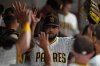 San Diego Padres starting pitcher Randy Vasquez is greeted by teammates after the third out during the seventh inning of a baseball game against the Milwaukee Brewers Tuesday, Sept. 23, 2025, in San Diego. (AP Photo/Gregory Bull)