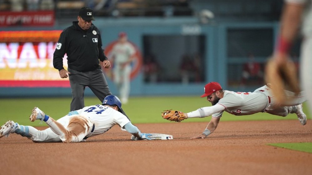 Los Angeles Dodgers' Andy Pages, left, dives back to second as Philadelphia Phillies second baseman Weston Wilson tries to tag him after Pages hit a double during the fifth inning of a baseball game Monday, Sept. 15, 2025, in Los Angeles. (AP Photo/Mark J. Terrill)