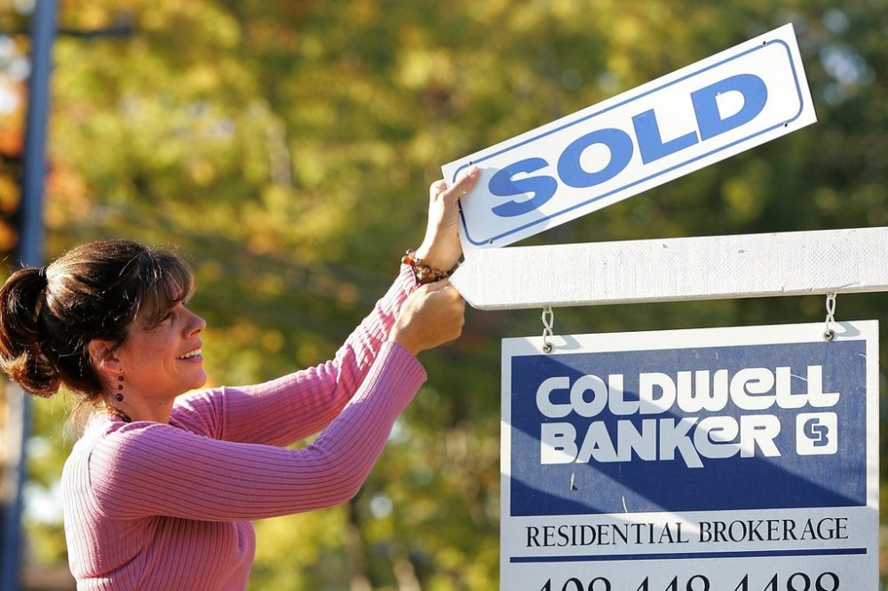 FILE - Coldwell Banker realtor Suzanne Hunter puts a sold sign on a home that she sold in Santa Clara, Calif., on Oct. 7, 2007. (AP Photo/Tony Avelar, File)