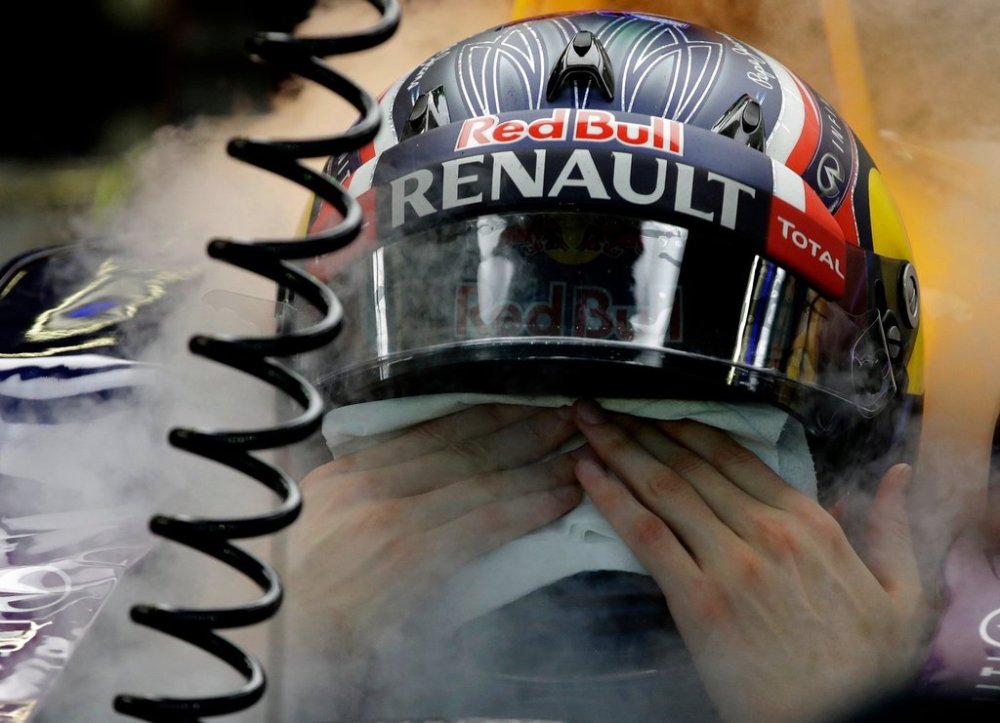 FILE -Red Bull driver Daniil Kvyat of Russia wipes the sweat from his face as he is cooled by dry ice during the third practice session at the Singapore Formula One Grand Prix on the Marina Bay City Circuit in Singapore, Sept. 19, 2015.(AP Photo/Mark Baker), File)