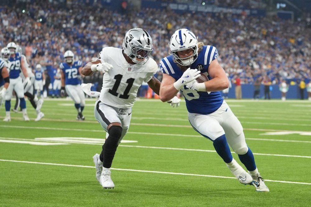 Indianapolis Colts tight end Tyler Warren (84) goes in for a touchdown against Las Vegas Raiders safety Jeremy Chinn (11) during the first half of an NFL football game, Sunday, Oct. 5, 2025, in Indianapolis. (AP Photo/Michael Conroy)