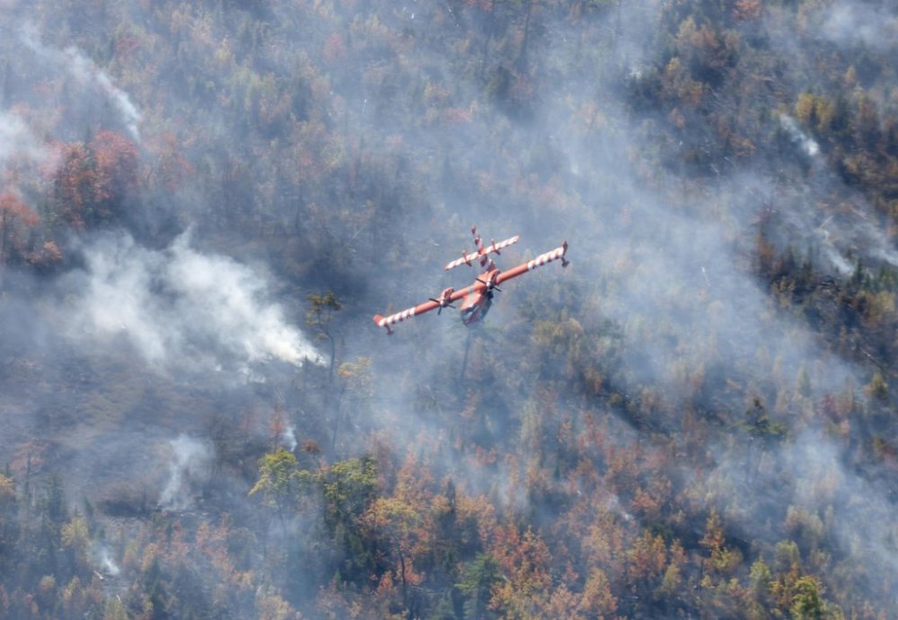 A plane from Newfoundland and Labrador flies over the Lake George wildfire near Aylesford, N.S. in this Friday, Oct. 3, 2025 handout photo. THE CANADIAN PRESS/Handout - Province of Nova Scotia (Mandatory Credit)