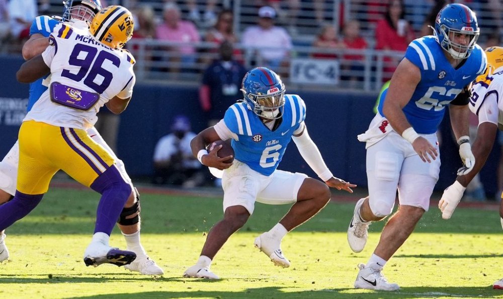Mississippi quarterback Trinidad Chambliss (6) tries to find an opening while offensive lineman Brycen Sanders (62), right, blocks a LSU defender during the second half of an NCAA college football game in Oxford, Miss., Saturday, Sept. 27, 2025. (AP Photo/Rogelio V. Solis)