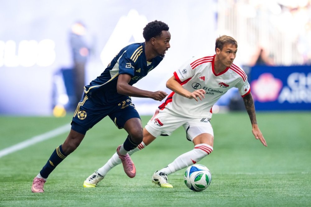 Vancouver Whitecaps' Ali Ahmed (22) and San Jose Earthquakes' Benji Kikanovic, right, vie for the ball during the first half of an MLS soccer match in Vancouver, on Sunday, October 5, 2025. THE CANADIAN PRESS/Ethan Cairns