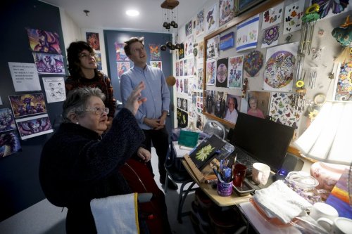 Cheryl Towers, a resident at Misericordia Place Personal Care Home, talks to artists Francesca Carella Arfinengo and Toby Gillies about her art in her care home room in Winnipeg, on Thursday, Sept. 25, 2025.  THE CANADIAN PRESS/John Woods