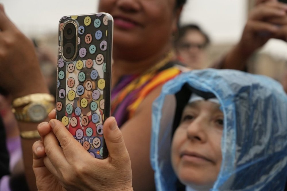 A faithful takes pictures with a mobile phone during the weekly general audience with Pope Leo XIV in St. Peter's Square, at the Vatican, Wednesday, Sept. 10, 2025. (AP Photo/Gregorio Borgia)