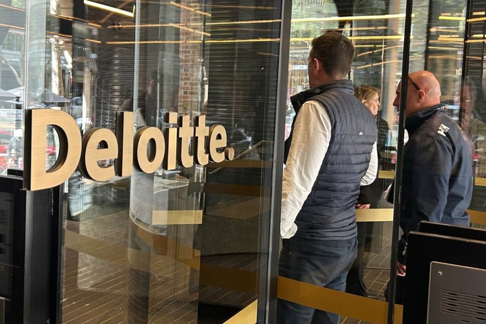 People arrive at the offices of Deloitte in Melbourne, Australia, on Tuesday, Oct. 7, 2025. (AP Photo/Rod McGuirk)