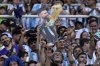 Argentina soccer fans hold a cardboard cutout with the image of soccer star Lionel Messi with the FIFA World Cup trophy as they wait for the start of an international friendly soccer match between Argentina and Curaçao in Santiago del Estero, Argentina, Tuesday, March 28, 2023. (AP Photo/Nicolas Aguilera)