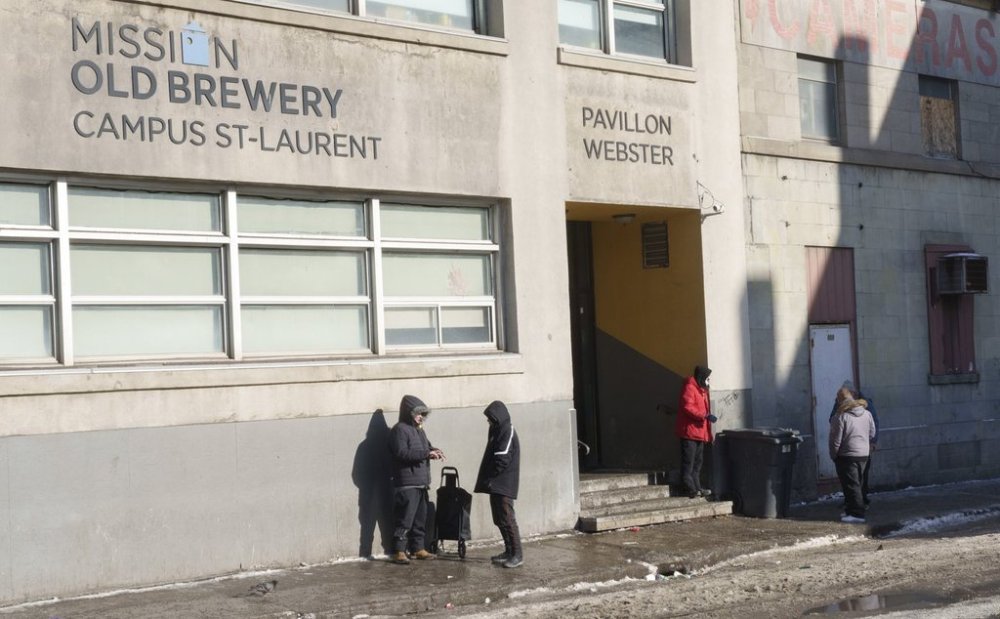 People stand outside the Old Brewery Mission in Montreal, Monday, Jan. 10, 2022. THE CANADIAN PRESS/Paul Chiasson
