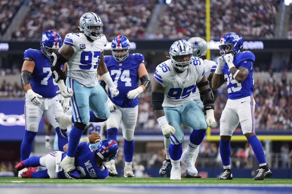 Dallas Cowboys' Kenny Clark (95) and Osa Odighizuwa (97) celebrate after Clark sacked New York Giants' Russell Wilson (3) in the first half of an NFL football game Sunday, Sept. 14, 2025, in Arlington, Texas. (AP Photo/Jeffrey McWhorter)