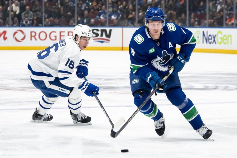 Vancouver Canucks' Brock Boeser (6) skates with the puck as Toronto Maple Leafs' Mitch Marner (16) defends during the first period of an NHL hockey game in Vancouver, on Saturday, February 8, 2025. THE CANADIAN PRESS/Ethan Cairns