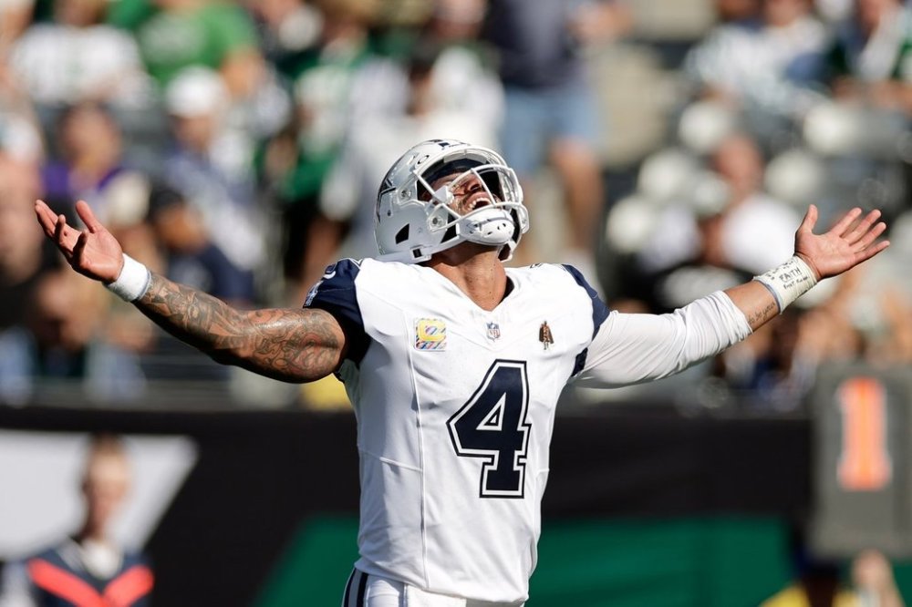 Dallas Cowboys' Dak Prescott reacts to a touchdown run by Javonte Williams during the first half of an NFL football game against the New York Jets Sunday, Oct. 5, 2025, in East Rutherford, N.J. (AP Photo/Adam Hunger)