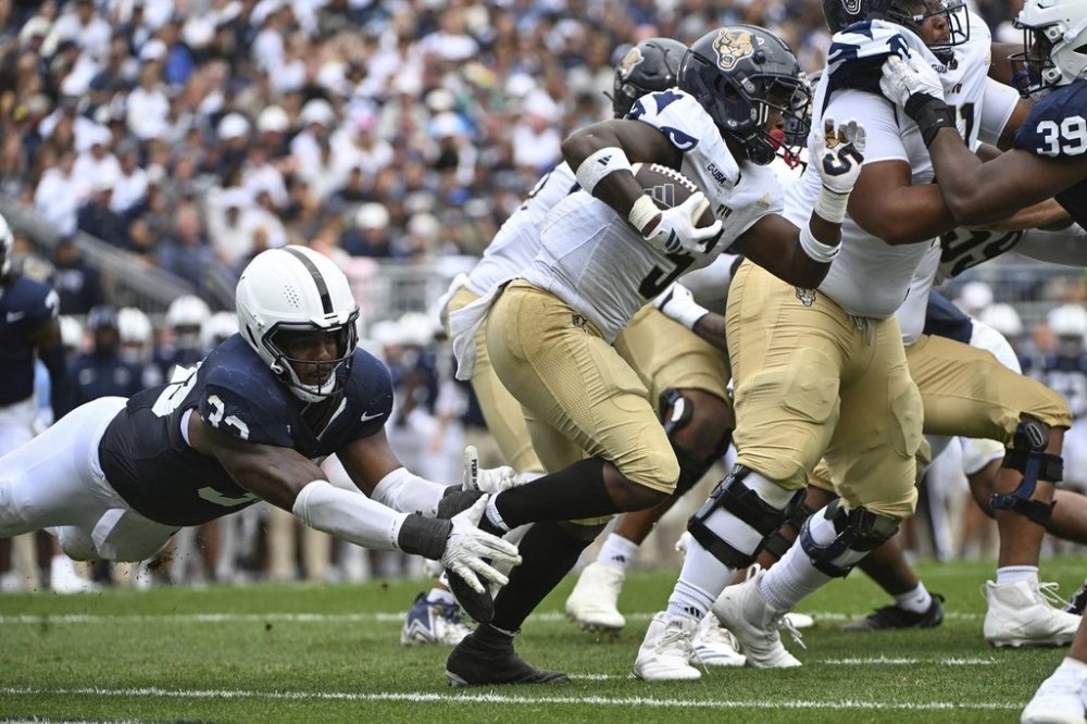 Penn State defensive end Dani Dennis-Sutton (33) attempts to tackle Florida International running back Kejon Owens (5) during the second quarter of an NCAA college football game, Saturday, Sept. 6, 2025, in State College, Pa. (AP Photo/Barry Reeger)