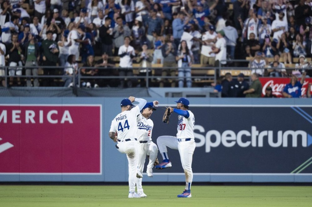 Los Angeles Dodgers left fielder Andy Pages, left, center fielder Tommy Edman, center, and right fielder Teoscar Hernández celebrate the team's win over the San Francisco Giants in a baseball game in Los Angeles, Friday, Sept. 19, 2025. (AP Photo/Kyusung Gong)