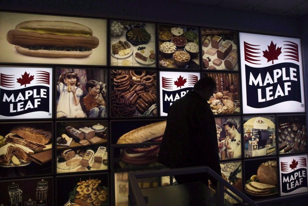 A Maple Leaf Foods employee walks past a Maple Leaf sign at the company's meat facility in Toronto on Monday, Dec., 15, 2008. THE CANADIAN PRESS/Nathan Denette