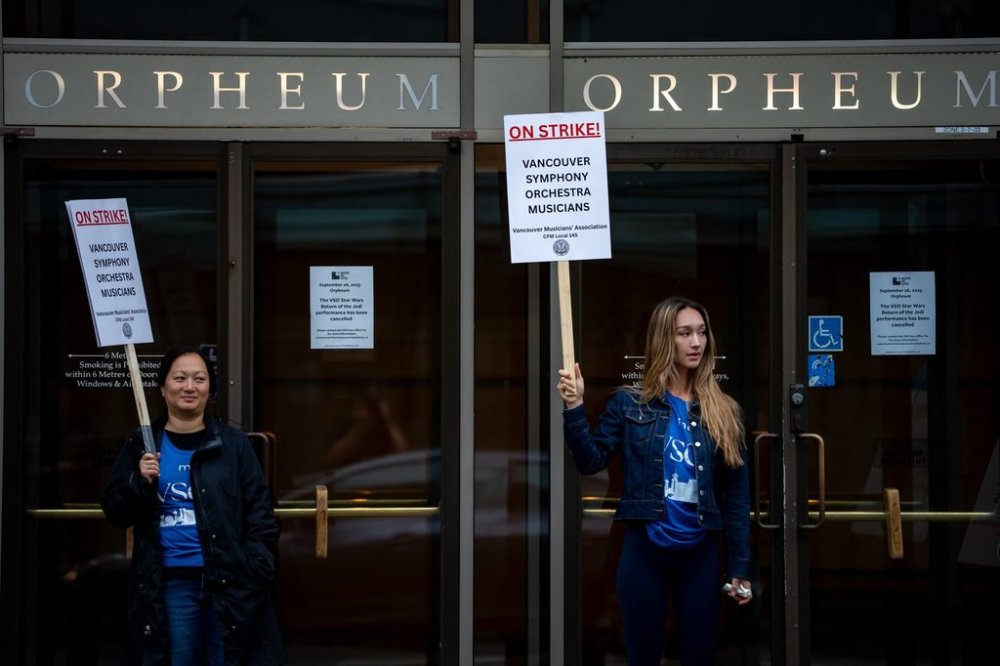 Vancouver Symphony Orchestra musicians picket outside the Orpheum Theatre in Vancouver, Friday, Sept. 26, 2025. Workers walked off the job Thursday afternoon, leading to the cancellation of concerts at the venue. THE CANADIAN PRESS/Ethan Cairns