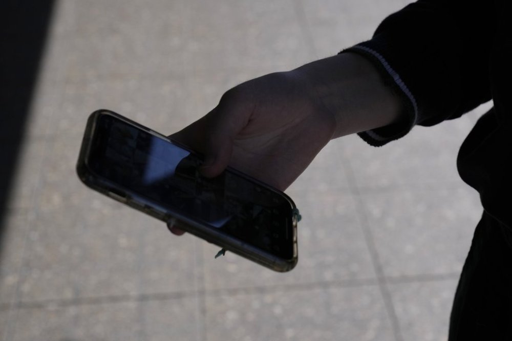 A teenager uses her phone in Sydney, Friday, Nov. 8, 2024. (AP Photo/Rick Rycroft)