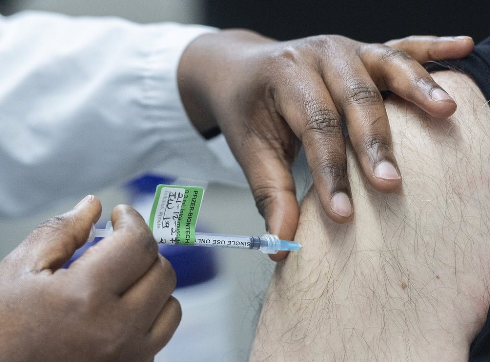 A man receives a Pfizer-BioNTech COVID-19 booster vaccine dose at the Olympic Stadium in Montreal, Monday, Dec. 27, 2021. THE CANADIAN PRESS/Graham Hughes