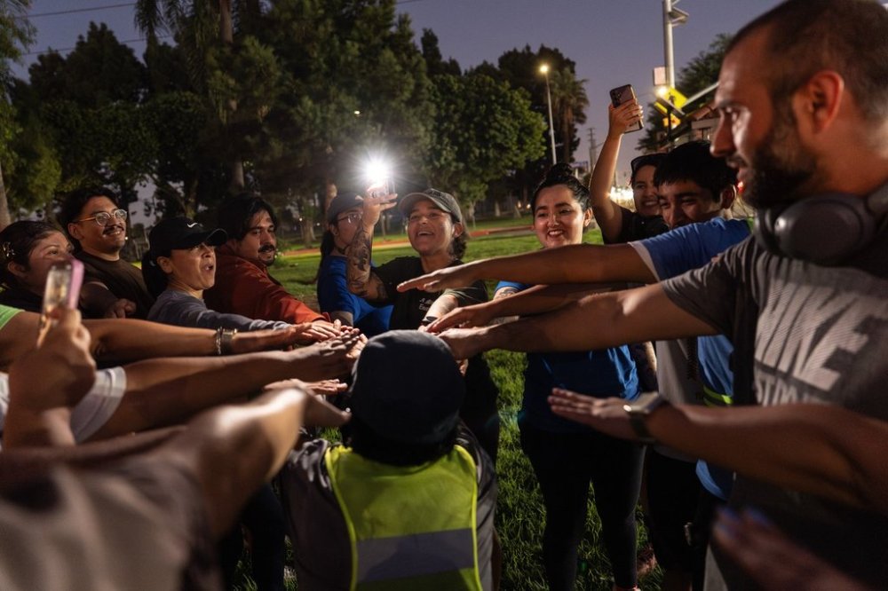 Iris Delgado, center, founder of the Huntington Park Run Club, leads a huddle after their run in Huntington Park, Calif., Sept. 24, 2025. (AP Photo/Jae C. Hong)