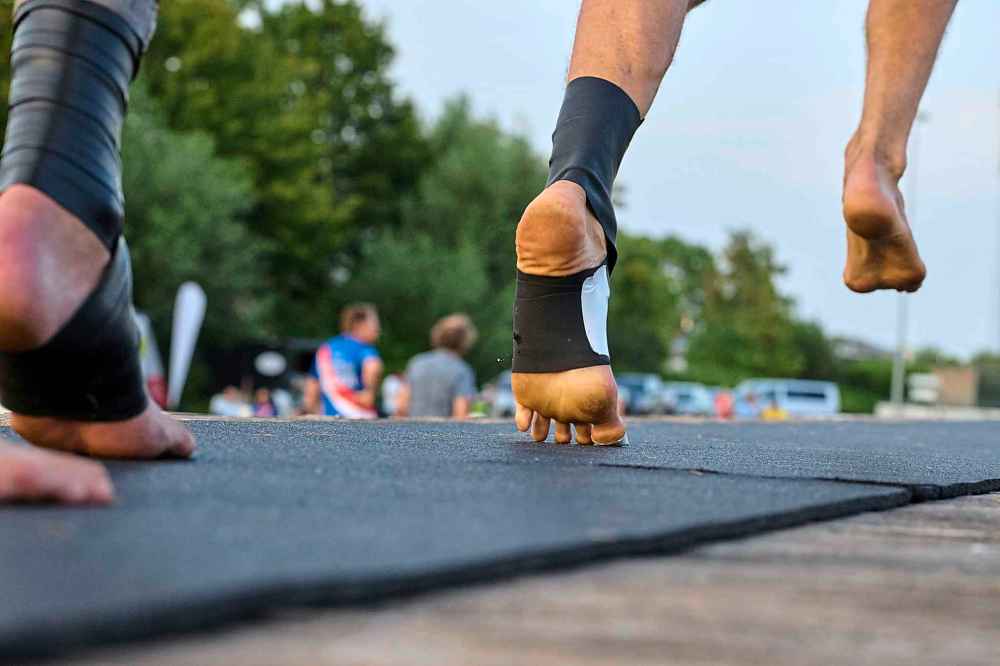 An athlete, wearing a rubber band on his foot to climb the pole, runs towards a long pole to jump across a body of water during a Fierljeppen competition in Kockengen, Netherlands, Wednesday, Aug. 27, 2025. (AP Photo/Peter Dejong)